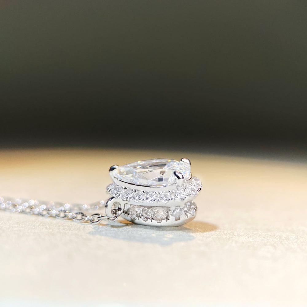 Sterling silver chain with pear-shaped Moissanite pendant, 1ct center stone with halo design.