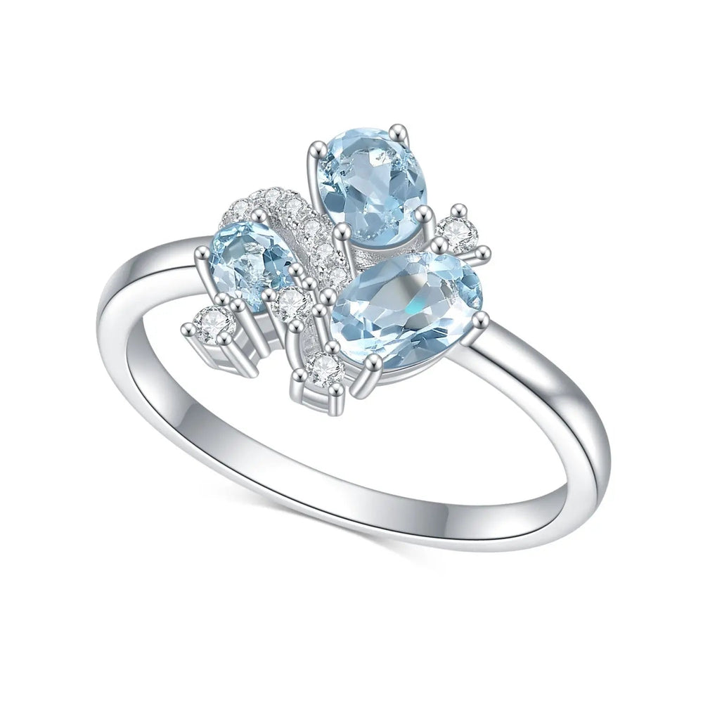 White gold blue topaz cluster ring with oval and round stones, slim band