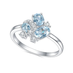 White gold blue topaz cluster ring with oval and round stones, slim band