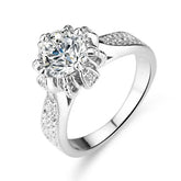 Floral-inspired 6-prong sterling silver engagement ring with round lab-created moissanite and pavé stones on the band