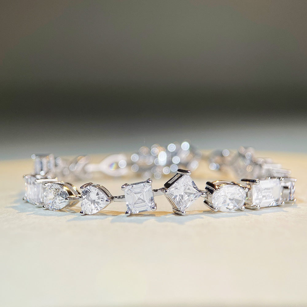 Mixed-shape moissanite tennis bracelet in platinum/18K white gold—heart, pear, oval, emerald cuts