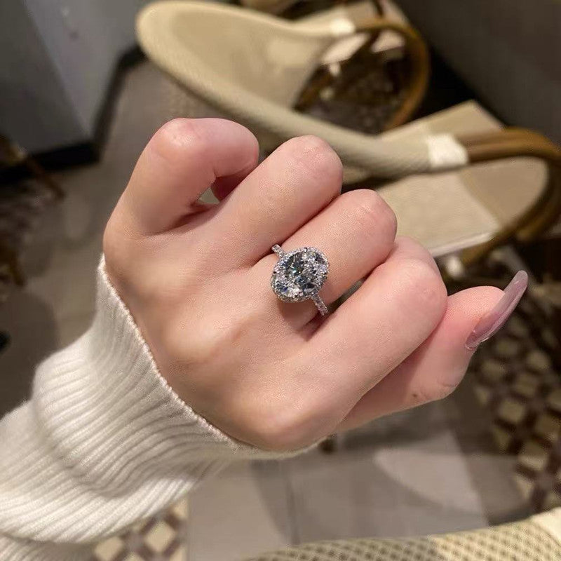 5ct oval halo moissanite statement ring with pavé band on white background