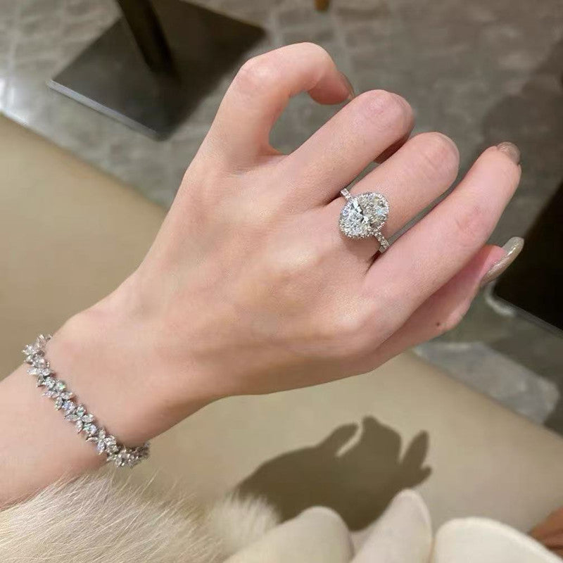 5ct oval halo moissanite statement ring with pavé band on white background