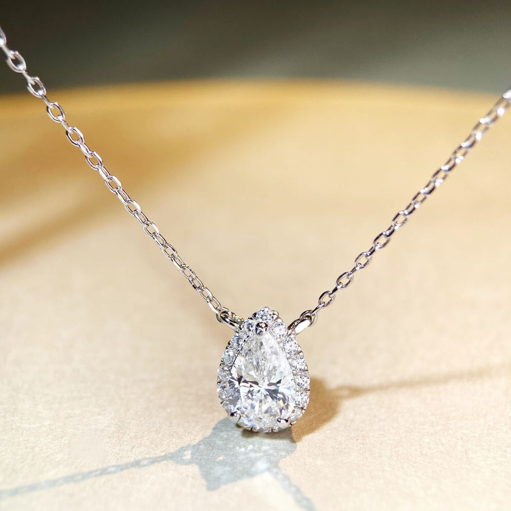 Elegant pear-cut Moissanite necklace displayed under soft light.