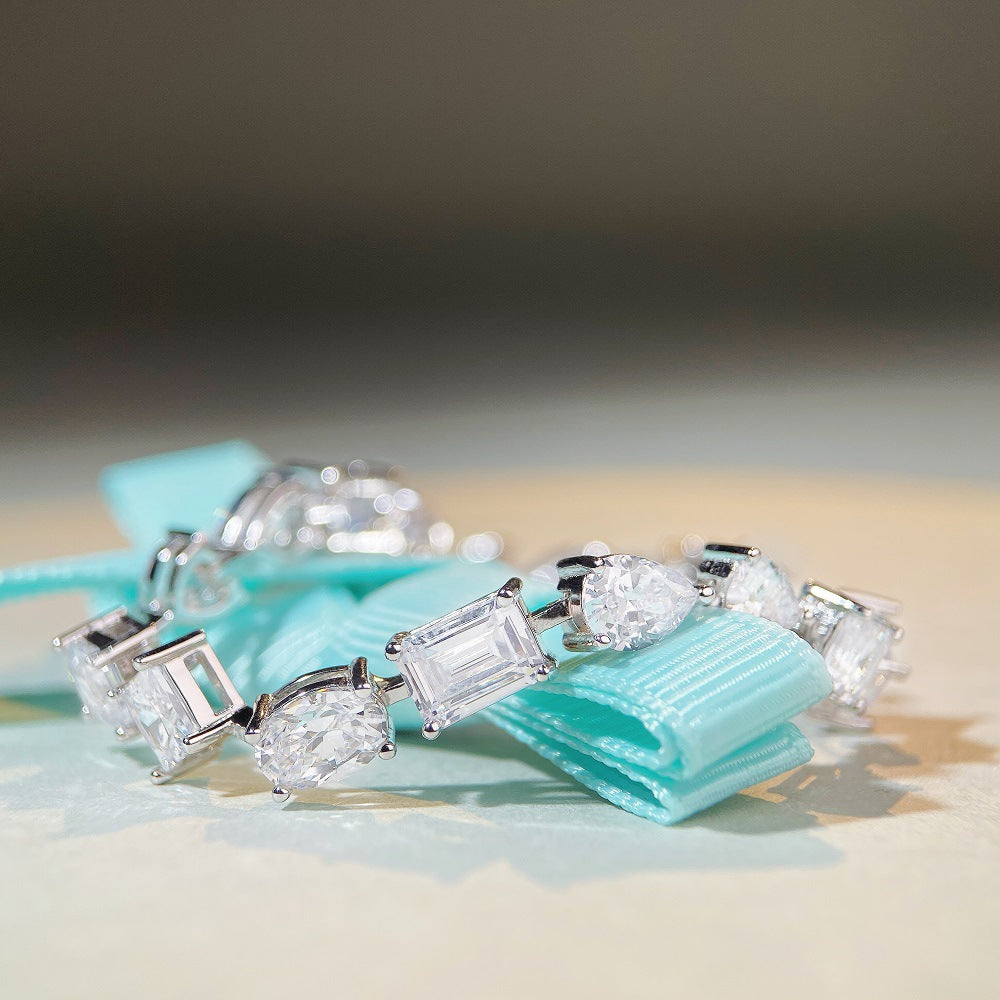 Mixed-shape moissanite tennis bracelet in platinum/18K white gold—heart, pear, oval, emerald cuts