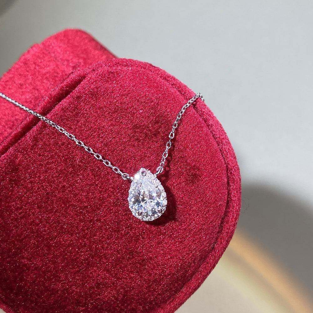 Sterling silver chain with pear-shaped Moissanite pendant, 1ct center stone with halo design.