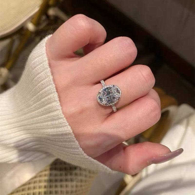 5ct oval halo moissanite statement ring with pavé band on white background