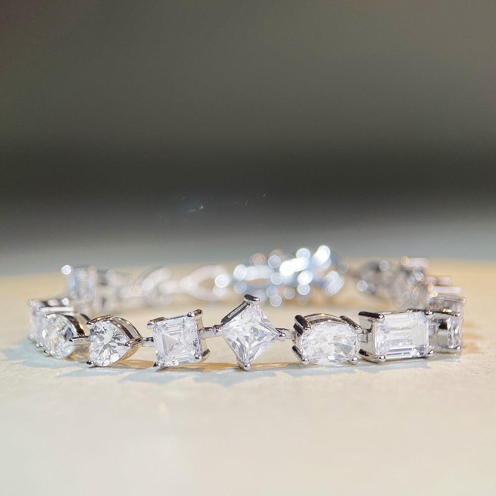 Mixed-shape moissanite tennis bracelet in platinum/18K white gold—heart, pear, oval, emerald cuts