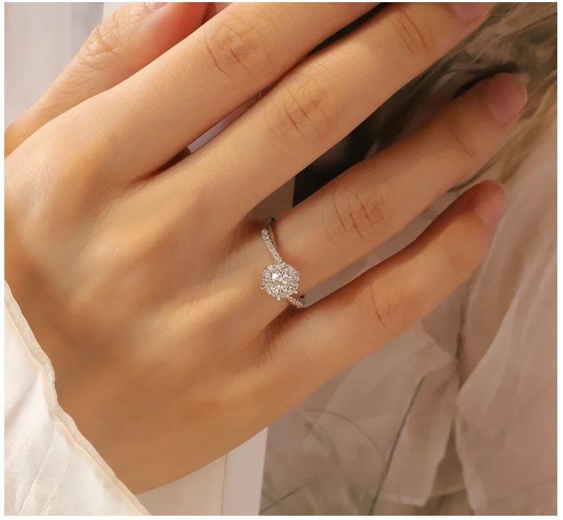 Elegant moissanite proposal ring in sterling silver with halo design"