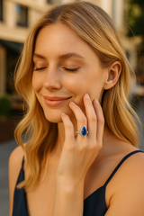 Woman wearing pear-cut sapphire halo ring, elegant evening look